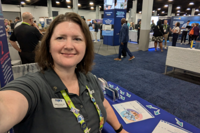 NSPRA Associate Director Mellissa Braham, APR, welcoming attendees of the 2024 ASBO Annual Conference & Expo to the NSPRA booth.